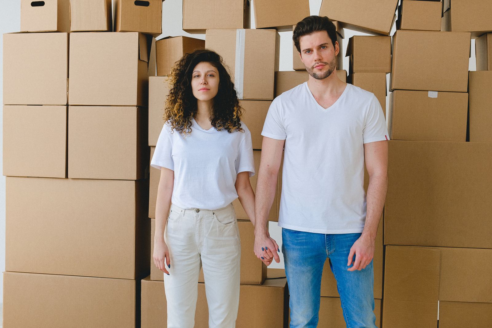 Couple standing in front of a stack of moving boxes